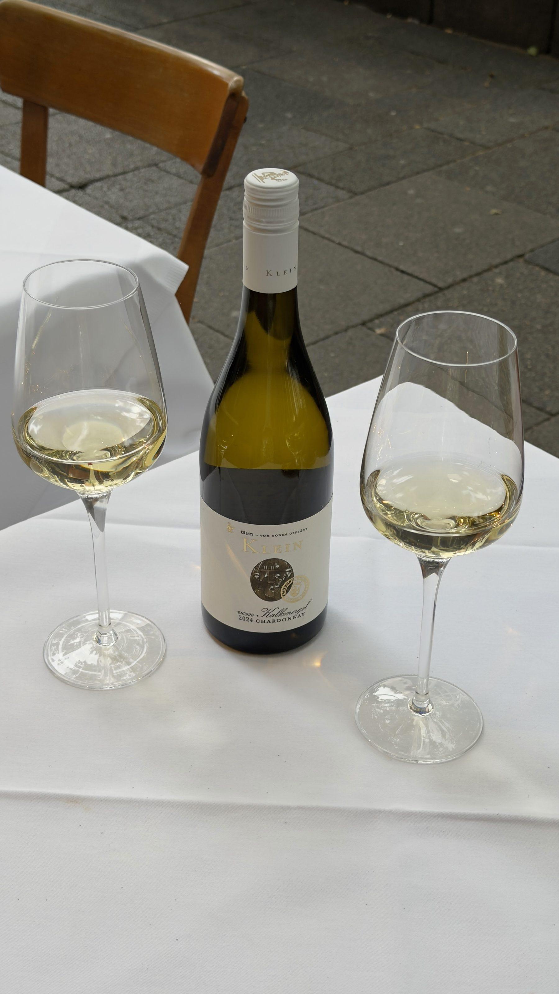 Flasche Chardonnay und zwei Gläser auf dem Pflaster